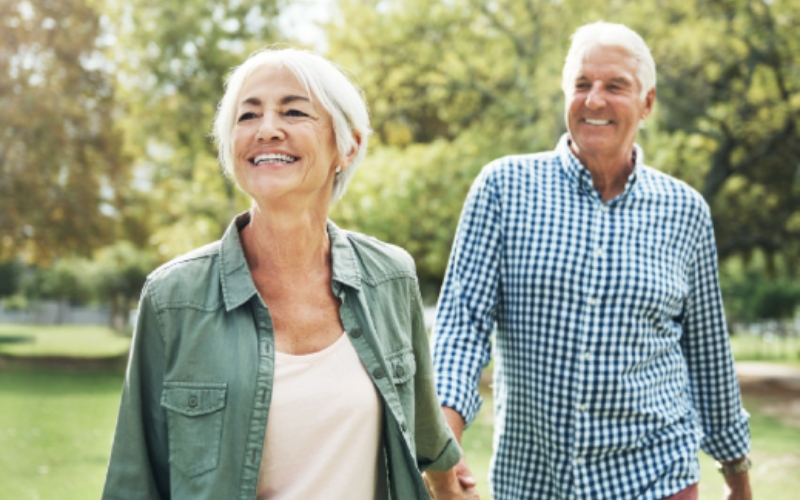 Casal de idosos felizes caminhando e sorrindo